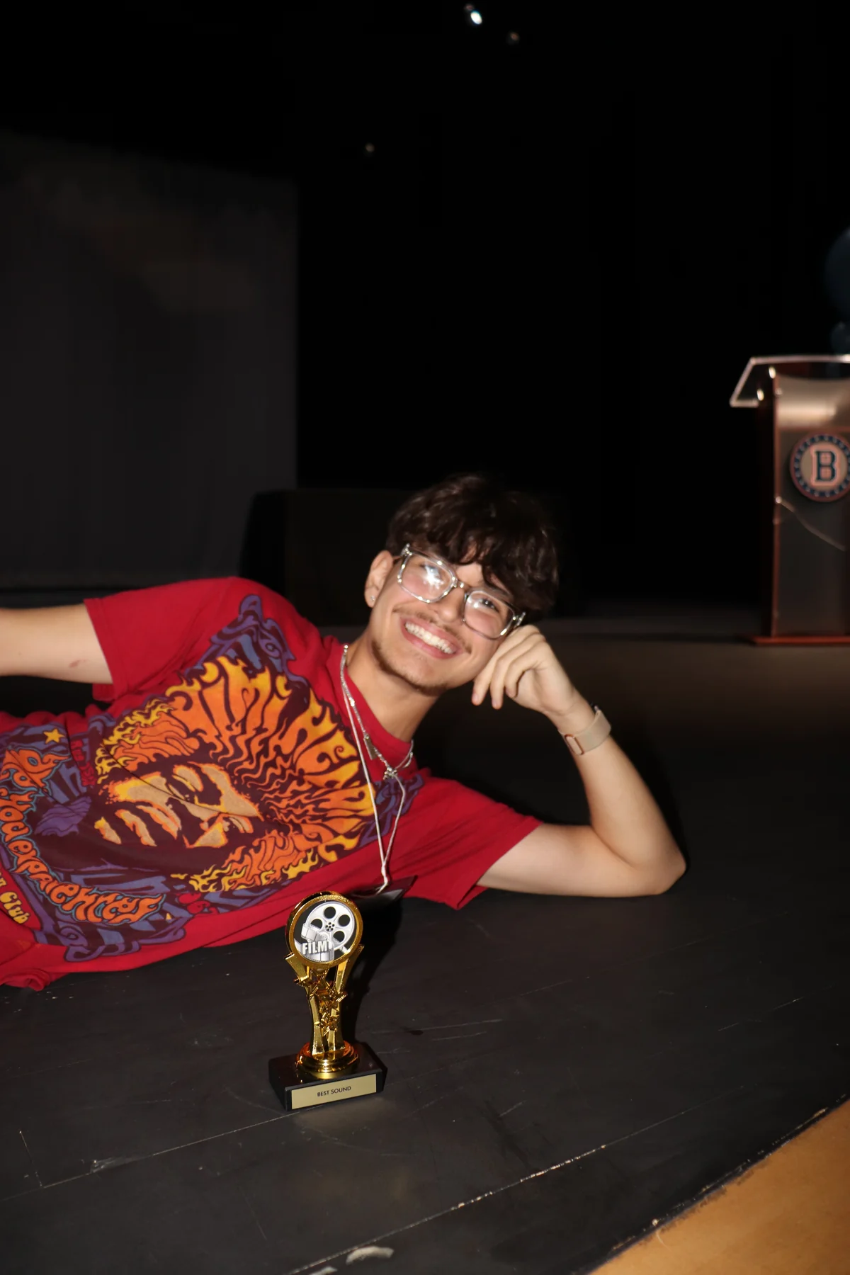 Thomas relaxing beside a small trophy during an evening event