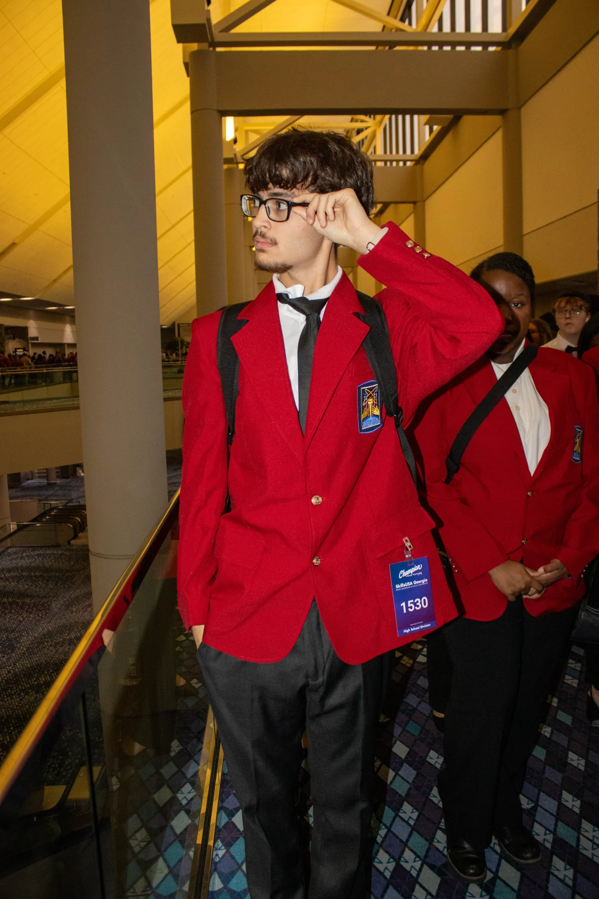 Thomas in a red suit with a camera hanging from his neck